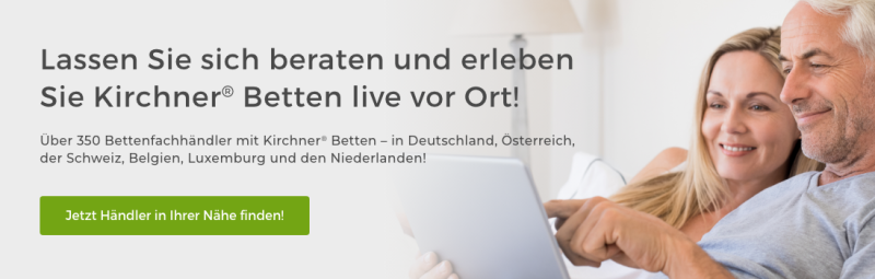 Besser schlafen in Kirchner Betten. Ein älteres Paar liegt im Bett und schaut in ein Tablet.